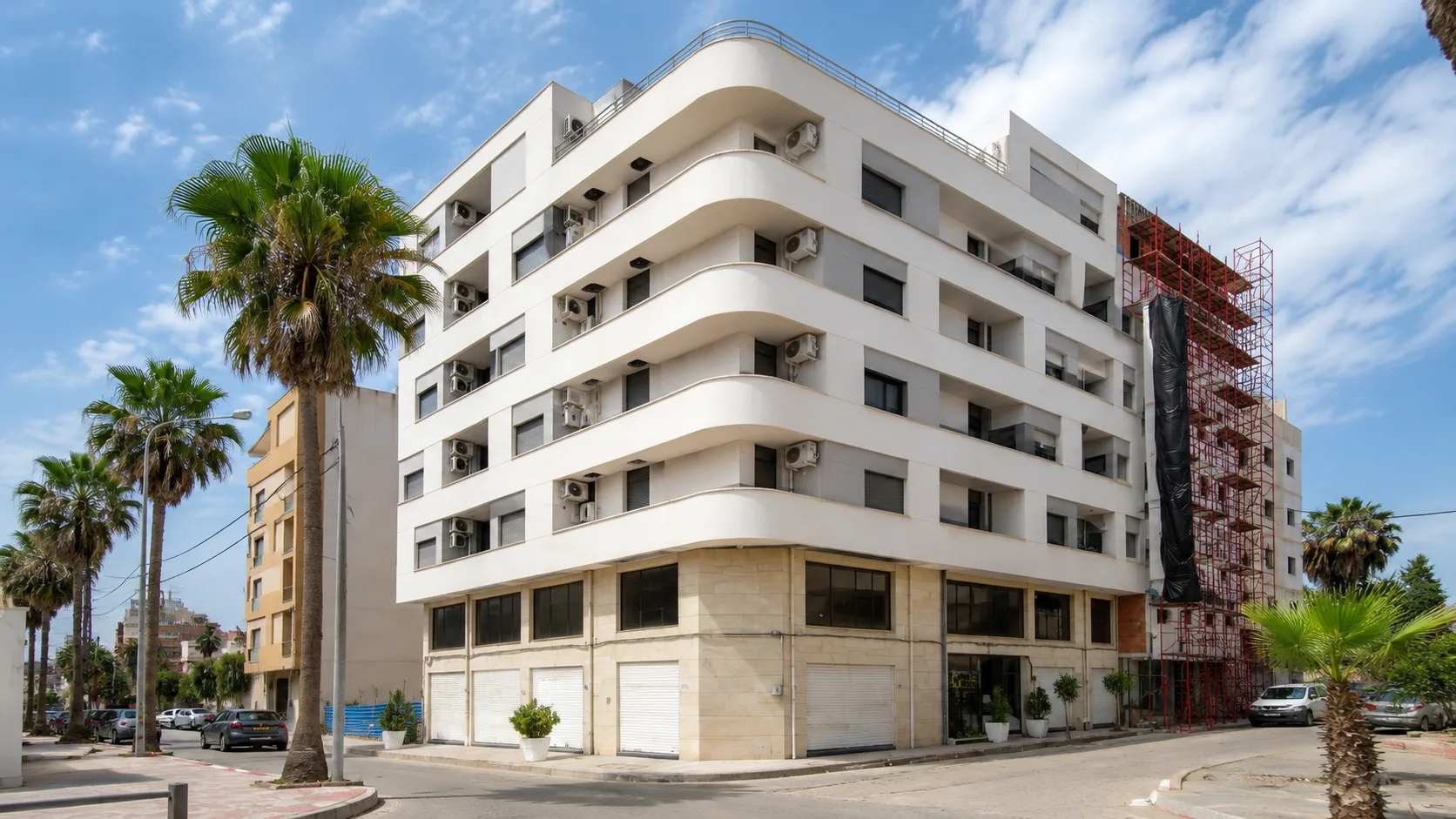 Résidence Aridj — façade d’angle blanche aux lignes courbes, Es Senia, Oran